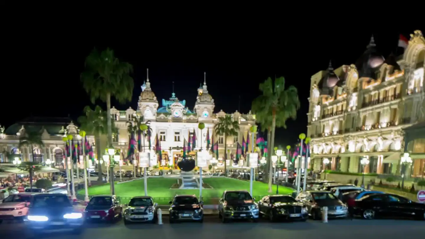 Place du Casino in Monte Carlo at night, traffic lights streaking past the Casino